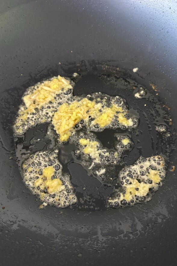 Garlic and ginger sizzling in hot oil at the beginning of the stir-fry