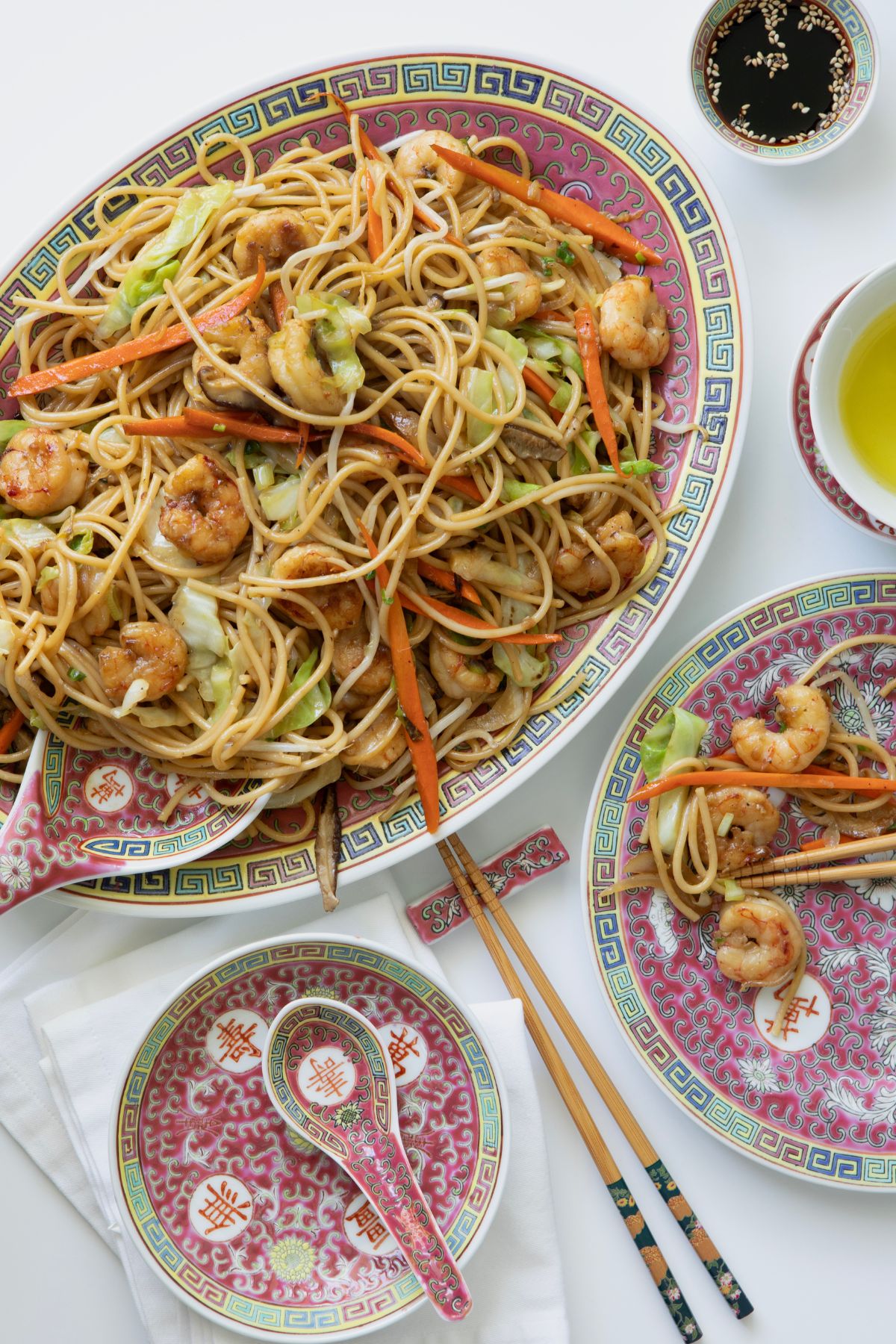 Overhead shot of shrimp lo mein plated with bean sprouts and scallion greens on top