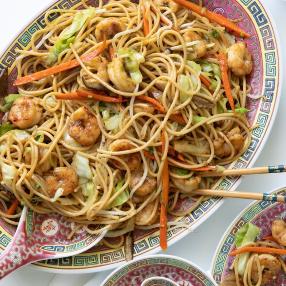 Overhead view of finished shrimp lo mein in a skillet with colorful vegetables and noodles