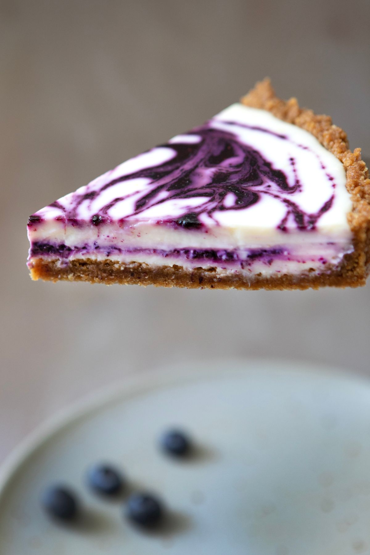 lifting a slice of blueberry lemon tart off of a plate
