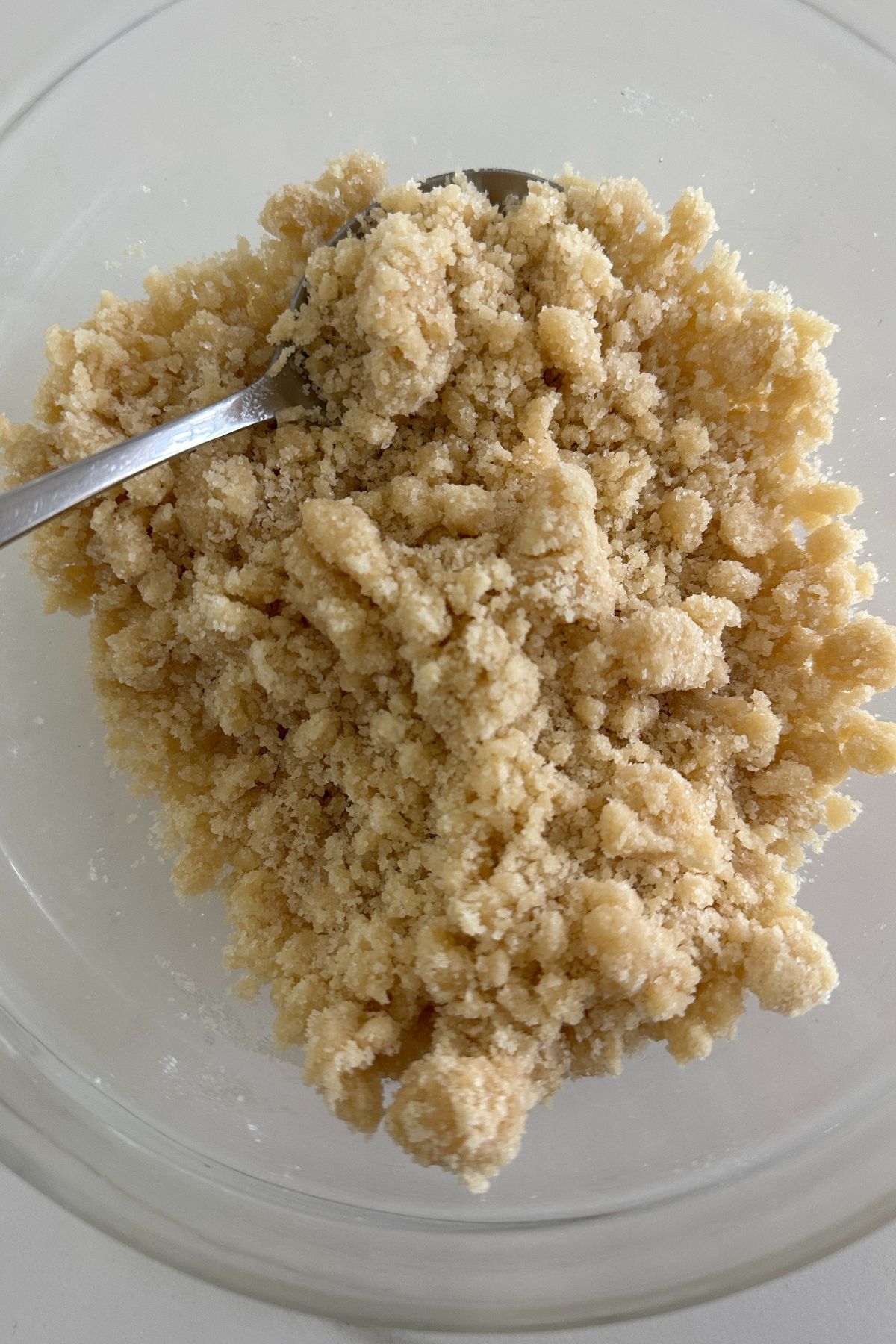 Coarse streusel crumb topping in a bowl with flour and sugar before baking