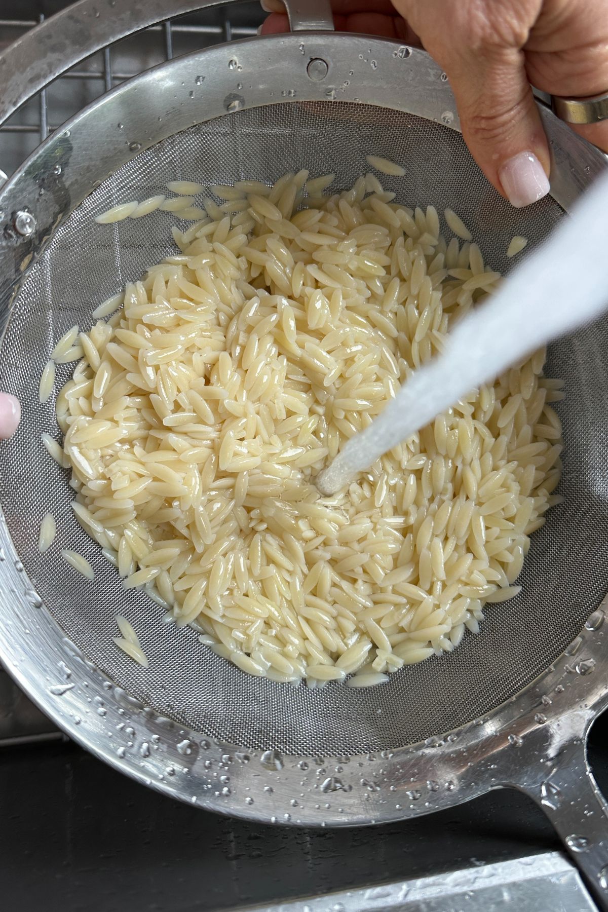 cooked orzo pasta draining in a colander 