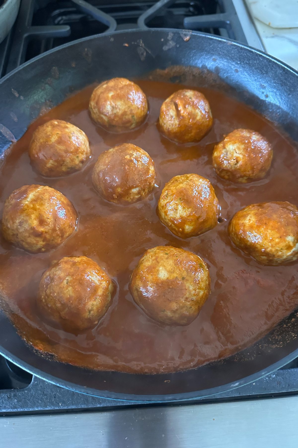 cooked meatballs finishing cooking in enchilada sauce