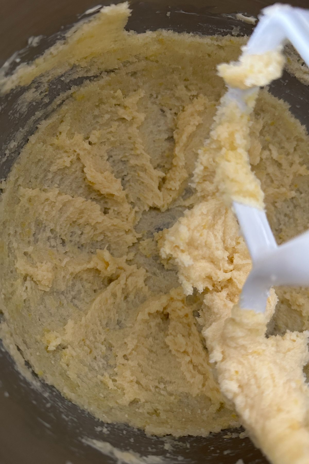 Egg, lemon juice, and vanilla being added to creamed butter mixture
