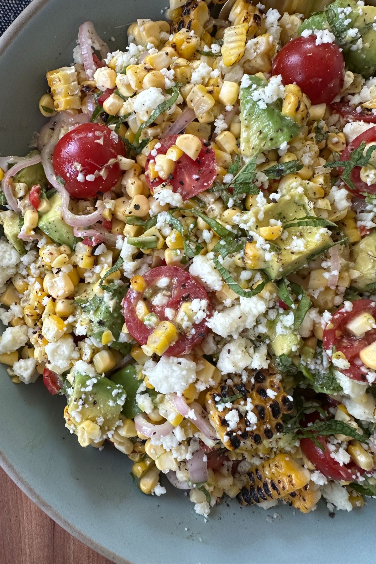 Close-up of a summer corn salad in a gray bowl.
