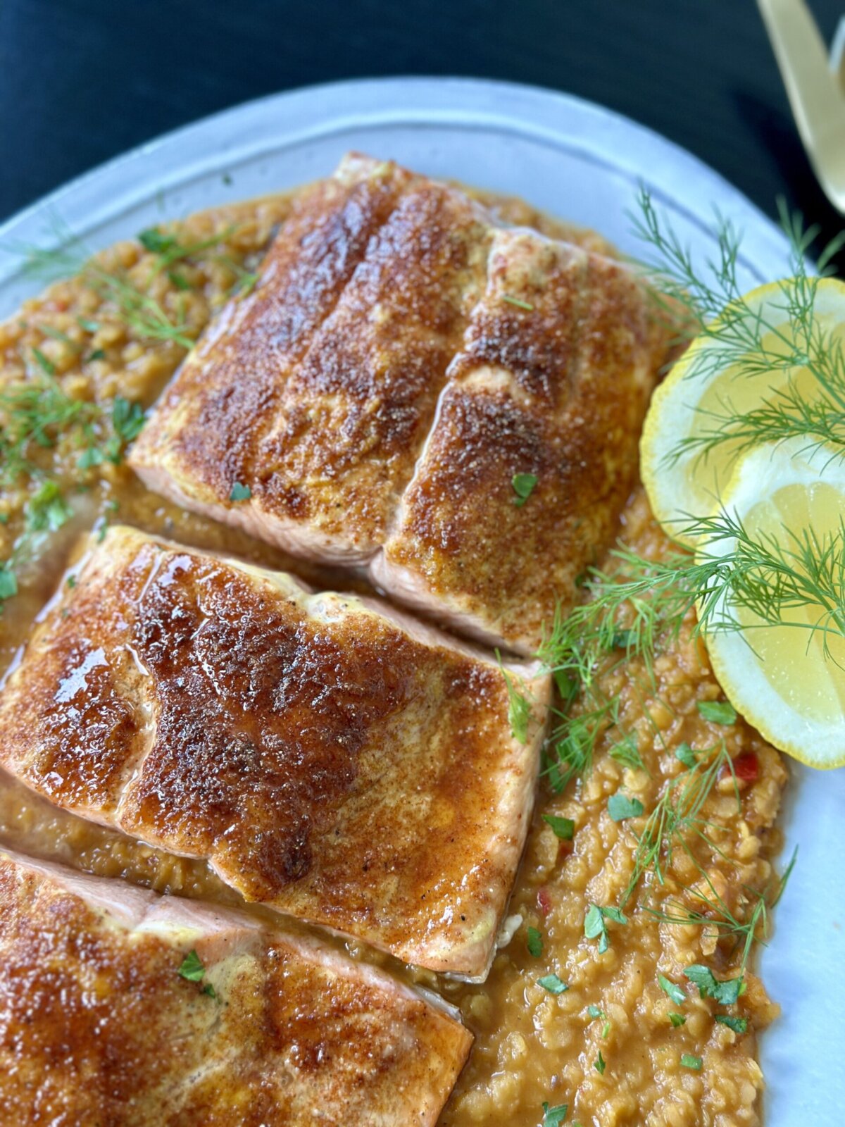 a close up shot of salmon on a plate with lentils